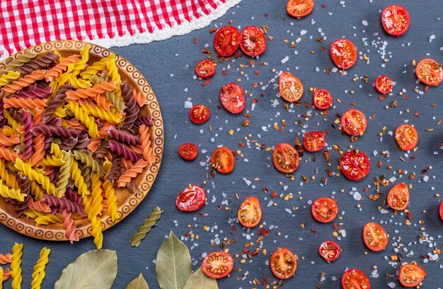 Foto pasta e fette di pomodoro su ardesia