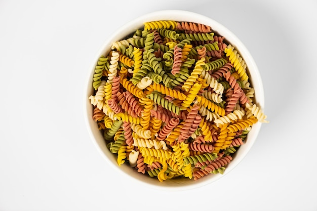 Pasta trottole tricolore stapel gemaakt van durumtarwe in een bord geïsoleerd op een witte achtergrond