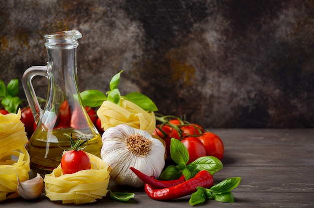 Pasta, vegetables, herbs and spices for Italian food on the wooden table.