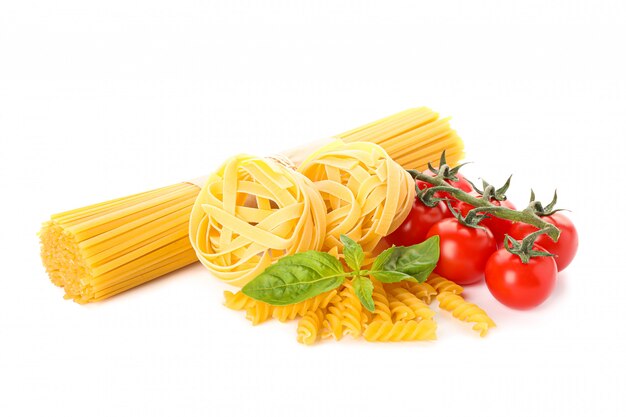 Pasta and vegetables isolated on white. Uncooked whole wheat pasta