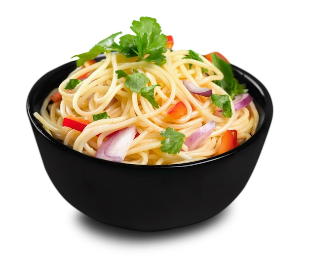 Pasta in a white bowl with tomato sauce and fresh basil set against a white napkin on a white table