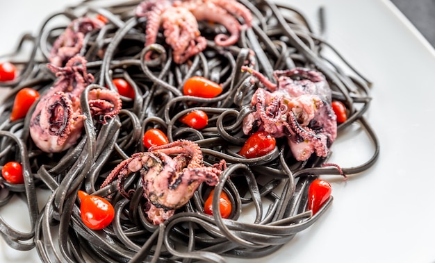 Pasta with black cuttlefish ink and small octopuses