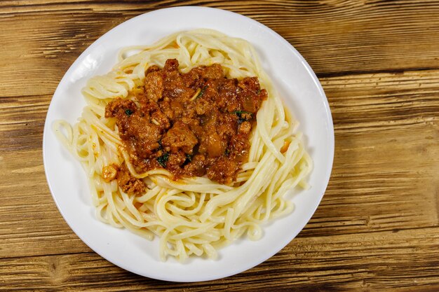 Pasta with bolognese sauce on wooden table