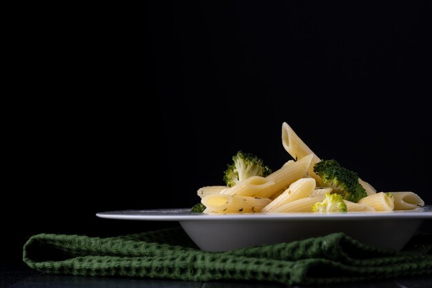 Pasta with broccoli on a black background