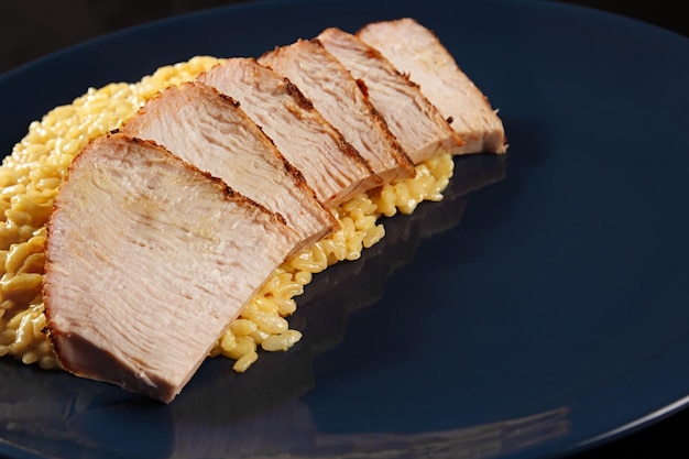 pasta with cheese and meat in a plate on a dark background close-up, tasty dish