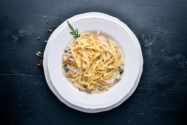 Pasta with chicken and mushrooms Italian cuisine On a wooden background Top view Free space for text