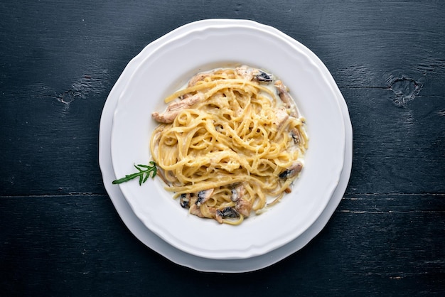 Pasta con pollo e funghi cucina italiana su fondo in legno vista dall'alto spazio libero per il testo