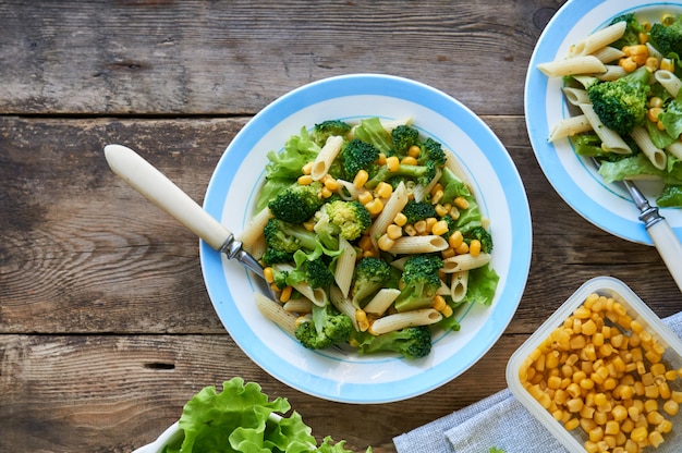 Pasta with corn, broccoli and lettuce on a plate