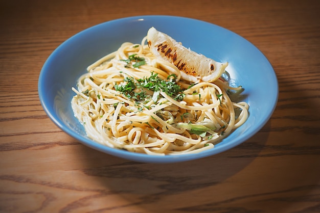 pasta with creamy sauce in blue plate and cocktail on the table