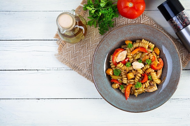 Pasta with fried chicken mushrooms pepper and pumpkin Top view