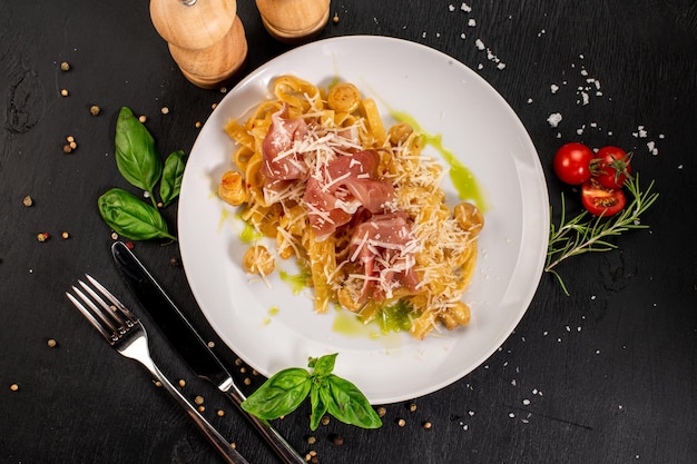 Pasta with ham and cheese parmesan on wooden background