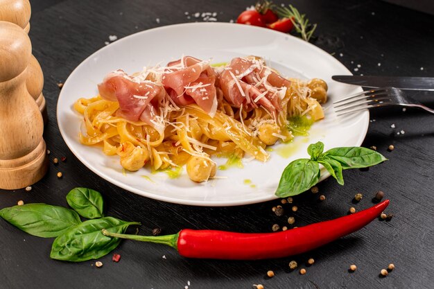 Pasta with ham and cheese parmesan on wooden background