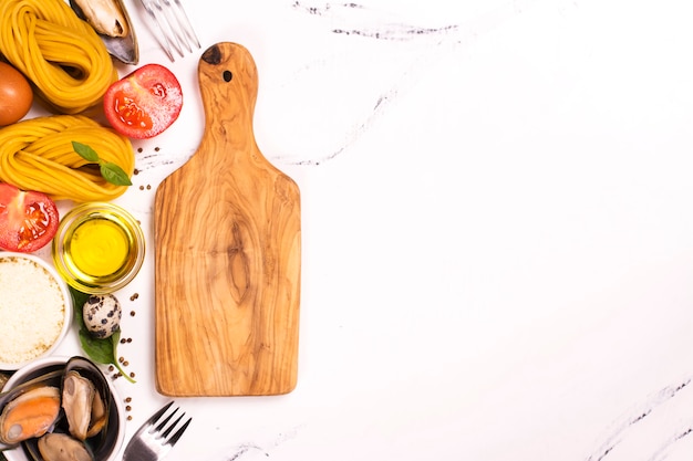 Pasta con ingredienti sul tavolo di marmo bianco