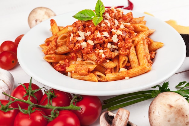 Pasta con carne, salsa di pomodoro e verdure sul tavolo