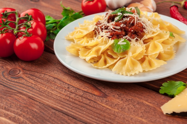 Pasta with meat, tomato sauce and vegetables on the table