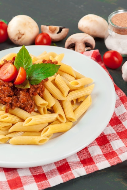 Pasta with meat, tomato sauce and vegetables on the table