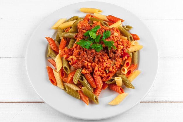 Pasta with meat, tomato sauce and vegetables on the table