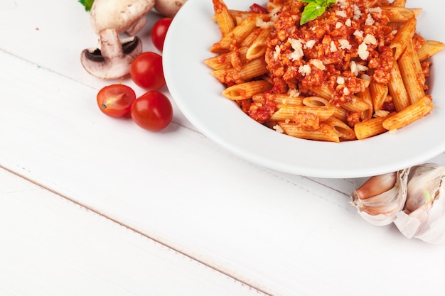 Pasta con carne, salsa di pomodoro e verdure sul tavolo