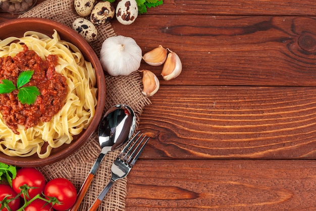 Pasta con carne, salsa di pomodoro e verdure sul tavolo