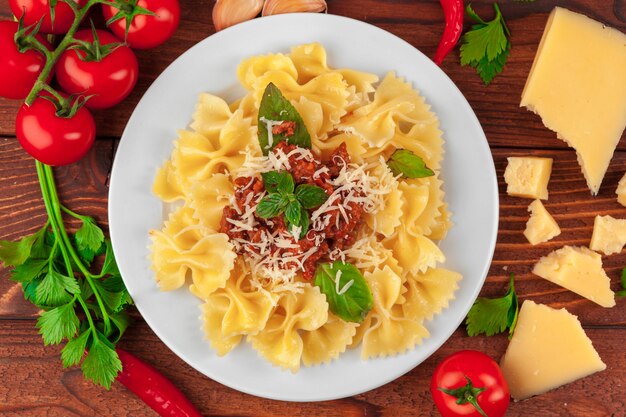 Pasta con carne, salsa di pomodoro e verdure sul tavolo