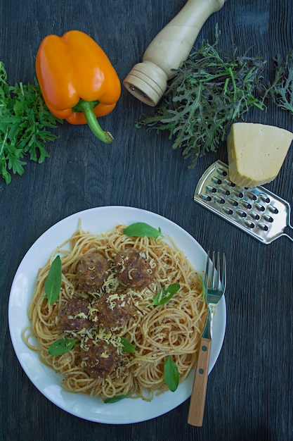 Pasta with meatballs and parsley in tomato sauce.