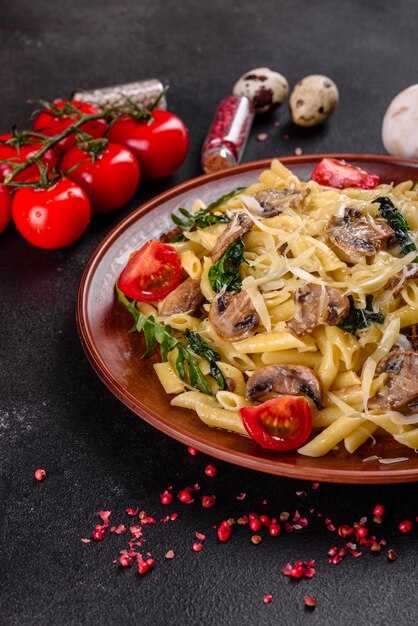 Pasta with mushrooms, cheese, spinach, rukkola and cherry tomatoes. Italian dish, Mediterranean culture