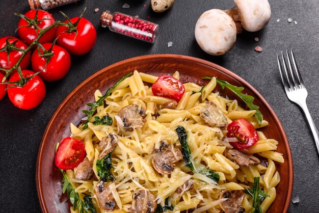 Pasta with mushrooms, cheese, spinach, rukkola and cherry tomatoes. Italian dish, Mediterranean culture