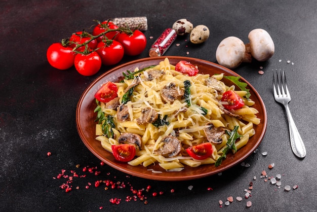 Pasta with mushrooms, cheese, spinach, rukkola and cherry tomatoes. Italian dish, Mediterranean culture