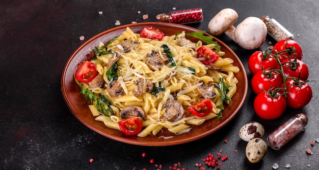 Pasta with mushrooms, cheese, spinach, rukkola and cherry tomatoes. Italian dish, Mediterranean culture