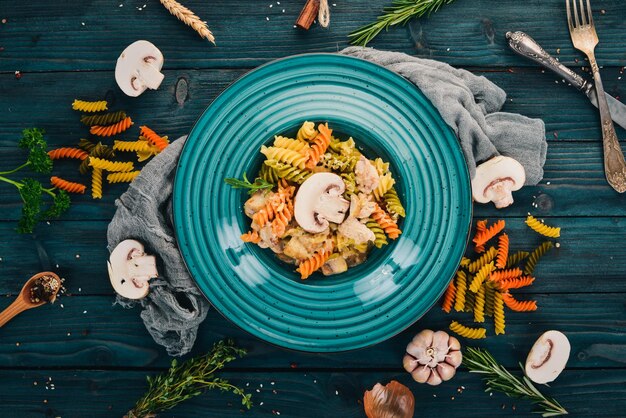 Pasta with mushrooms and chicken On a wooden background Italian cuisine Top view Copy space