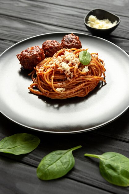 Pasta with red tomato sauce on a black plate