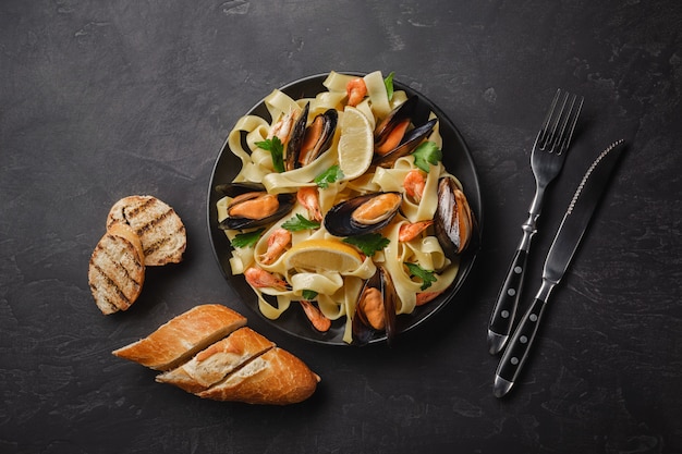 Pasta with seafood on stone table. Mussels and prawns. Top view with copy space.