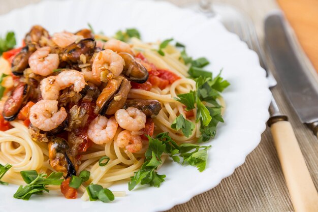 Pasta with seafoods and white wine on napkin