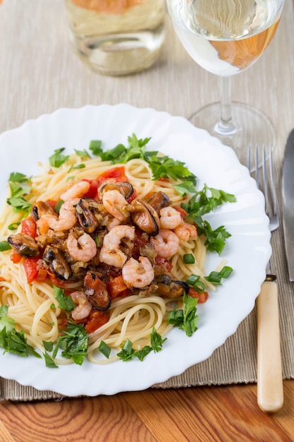 Pasta with seafoods and white wine on napkin