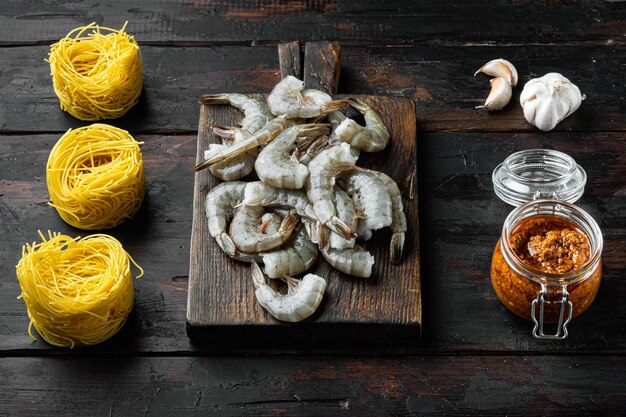 Pasta with shrimp, tomato and pesto sauce ingredients set, on old dark  wooden table