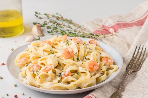 Pasta con gamberi, salsa cremosa, parmigiano e timo su un piatto. fettuccine mediterranee ai frutti di mare