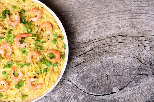 Pasta with shrimps on wooden background