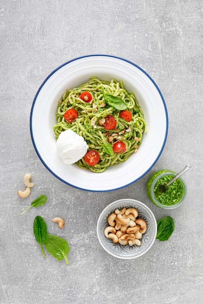 Pasta with spinach pesto cashew nuts and soft cream cheese Top view