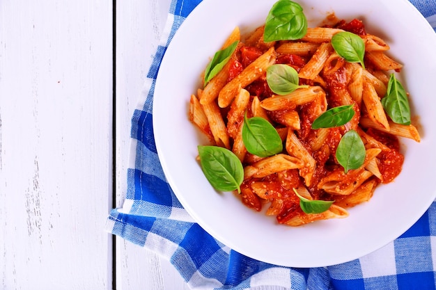 Foto pasta con salsa di pomodoro e basilico sul tavolo da vicino