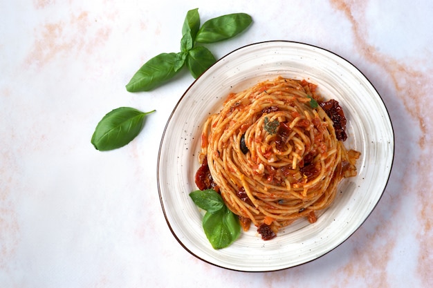 Foto pasta con salsa di pomodoro, pomodori secchi e olive