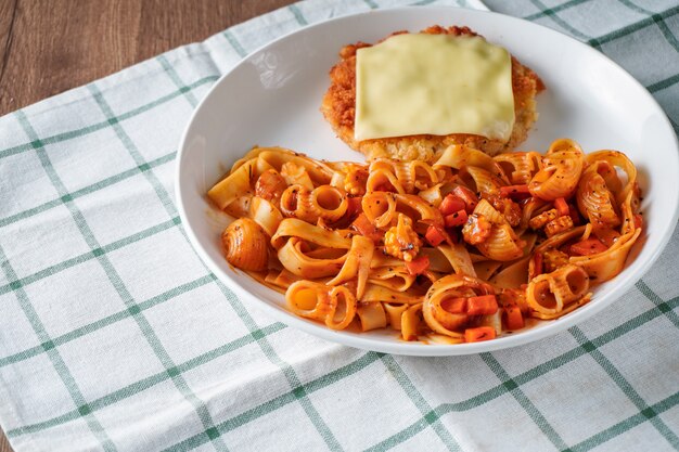 Pasta with tomato sauce topping, deep fried crispy pork cutlet and a sheet of cheese