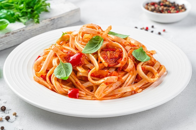 Pasta with tomatoes pepper and garlic on a light gray background closeup