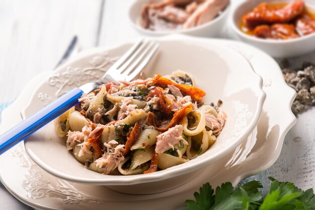 Pasta con tonno pomodori secchi e capperi a fuoco selettivo