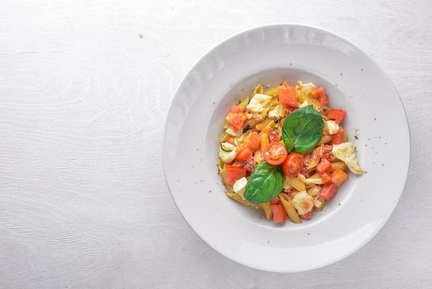 Паста с овощами, базиликом и сыром пармезан Итальянская кухня На деревянном фоне Вид сверху Свободное место для текста