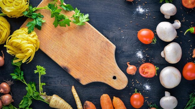 Pasta with vegetables cherry tomatoes chili peppers and garlic On a wooden background Free space for text  Top view