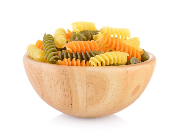 Pasta in wooden bowl on white wall