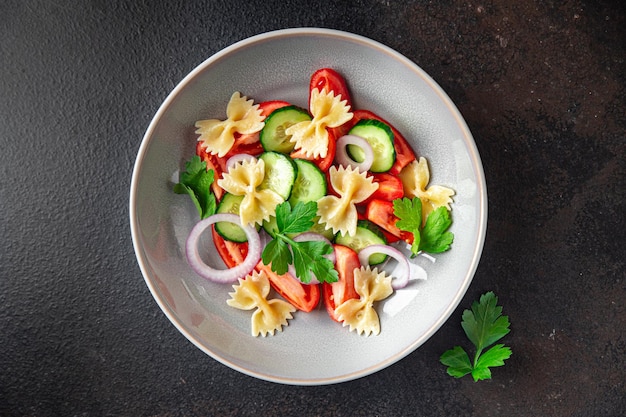 Pastasalade farfalle tomaat komkommer ui gezonde maaltijd dieet snack op tafel