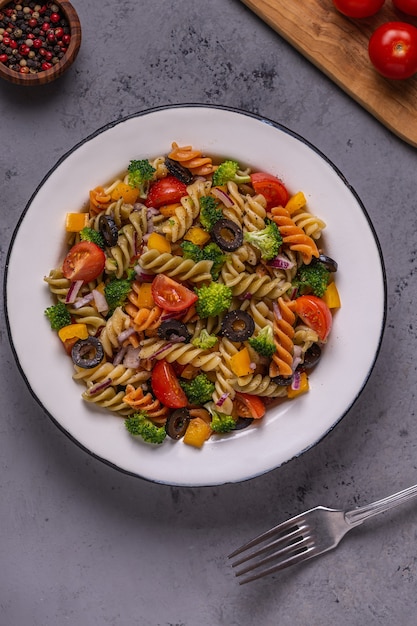 Pastasalade met tomaat, broccoli, zwarte olijven. Bovenaanzicht