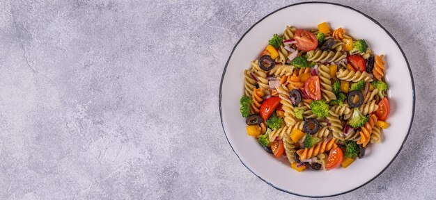 Pastasalade met tomaat, broccoli, zwarte olijven. Bovenaanzicht