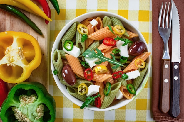 Pastasalade met tomaatrucola komkommer peppershot pepers zwarte en groene olijven